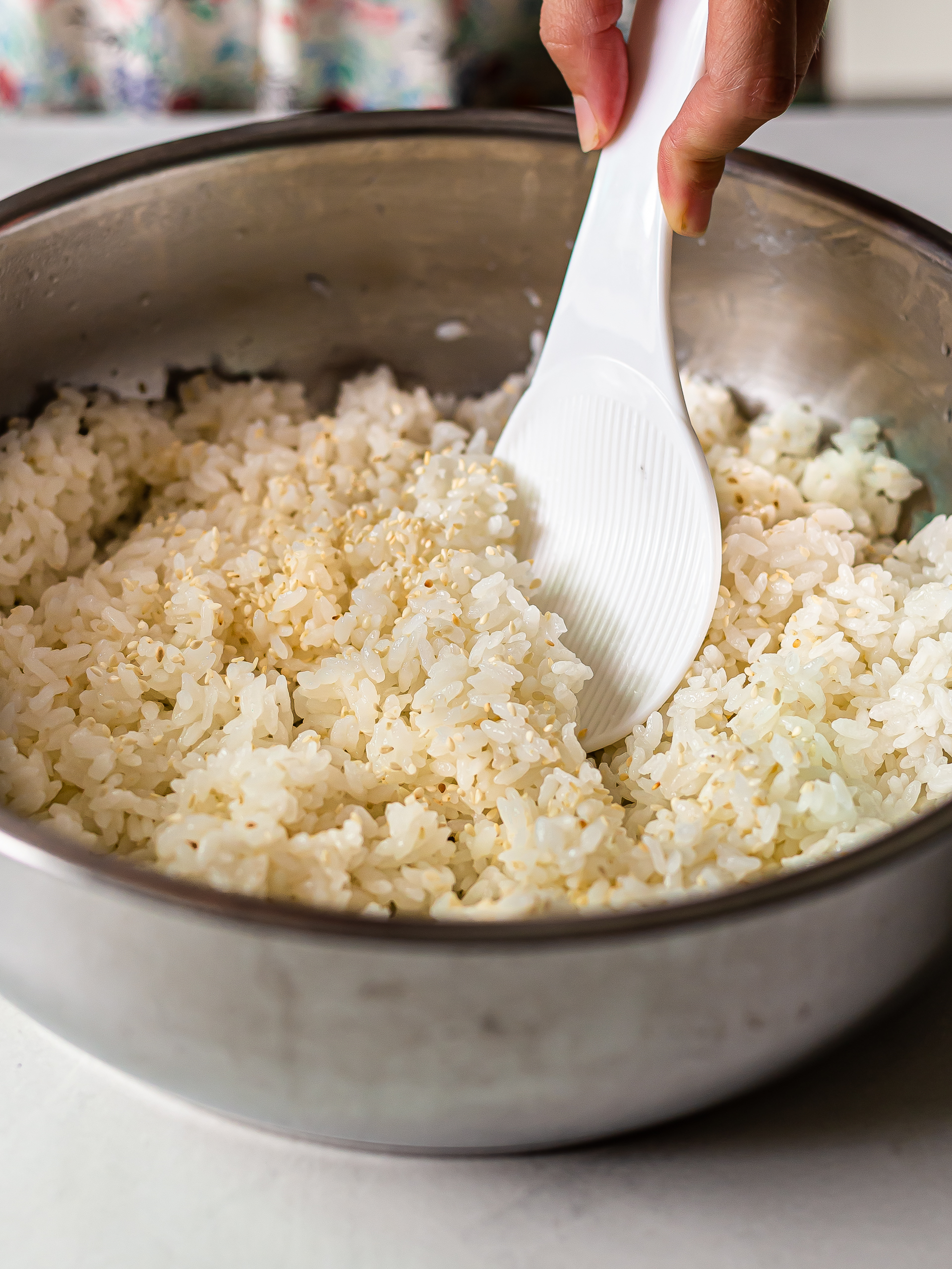 sushi rice in a pot mixed with sesame seeds