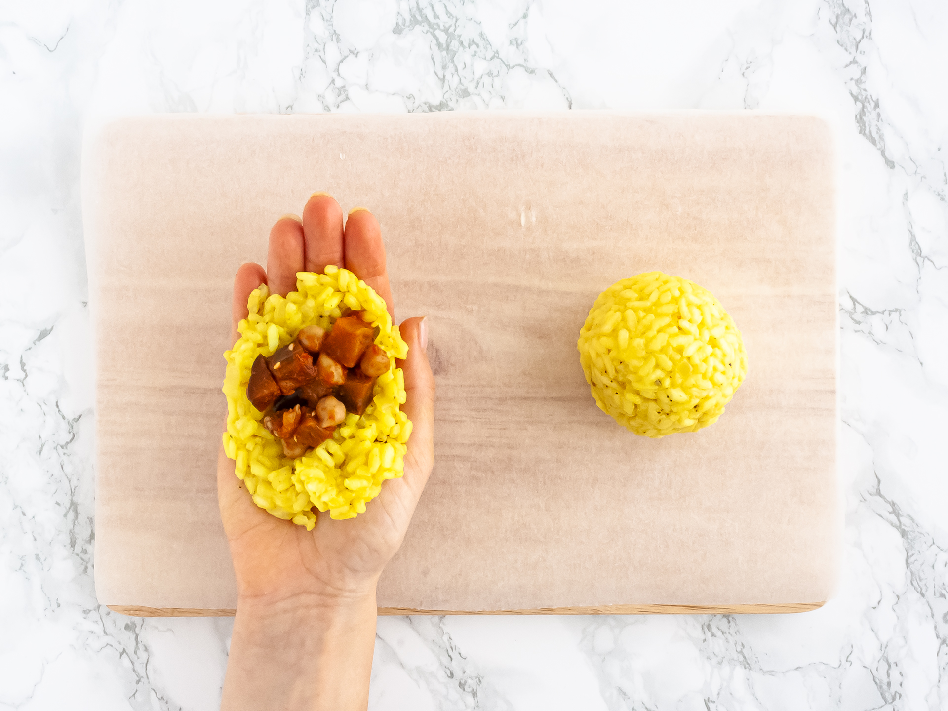 Filling the rice balls with chickpeas and aubergines.