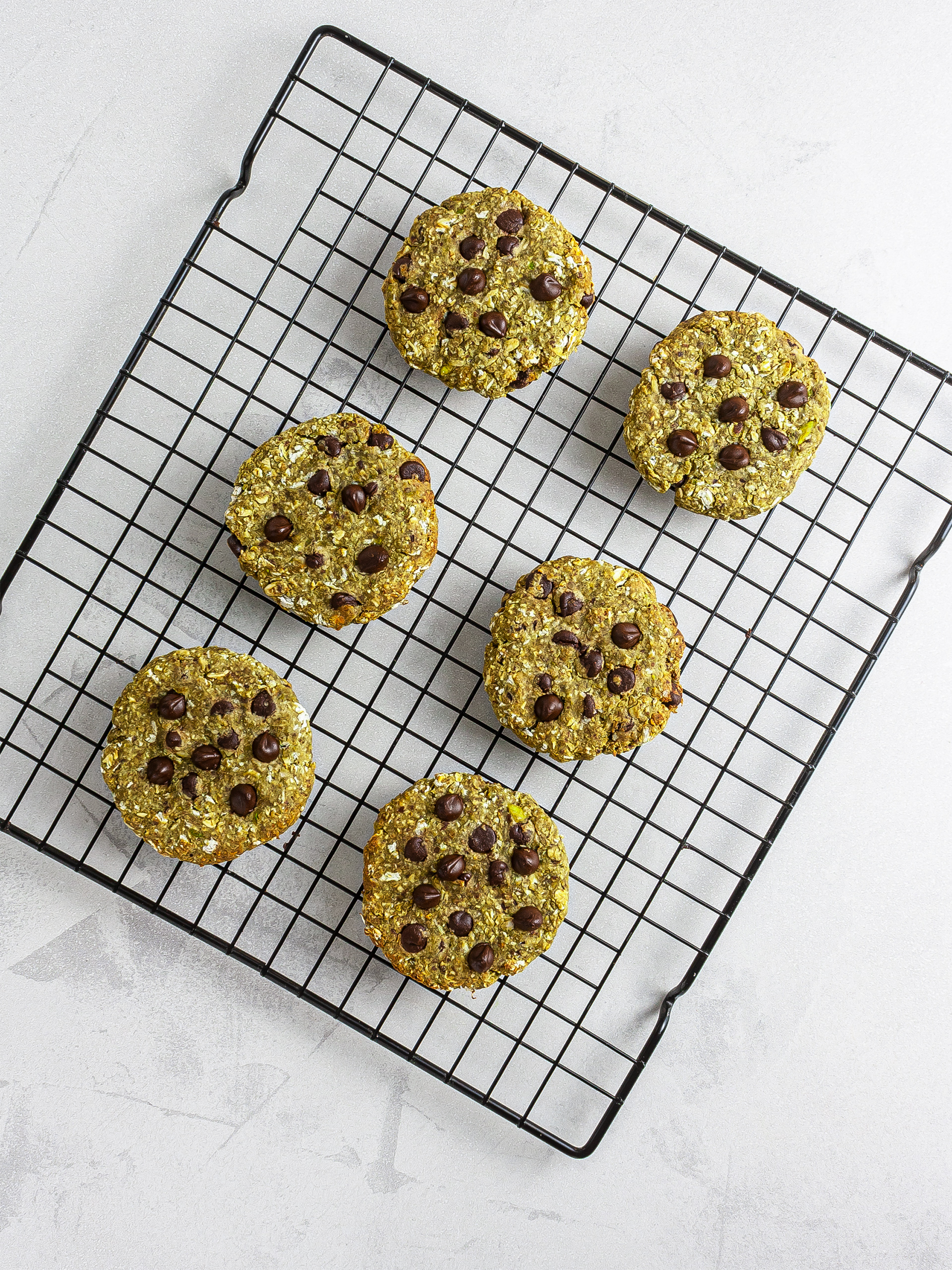 Baked matcha chocolate chip cookies on a wire rack