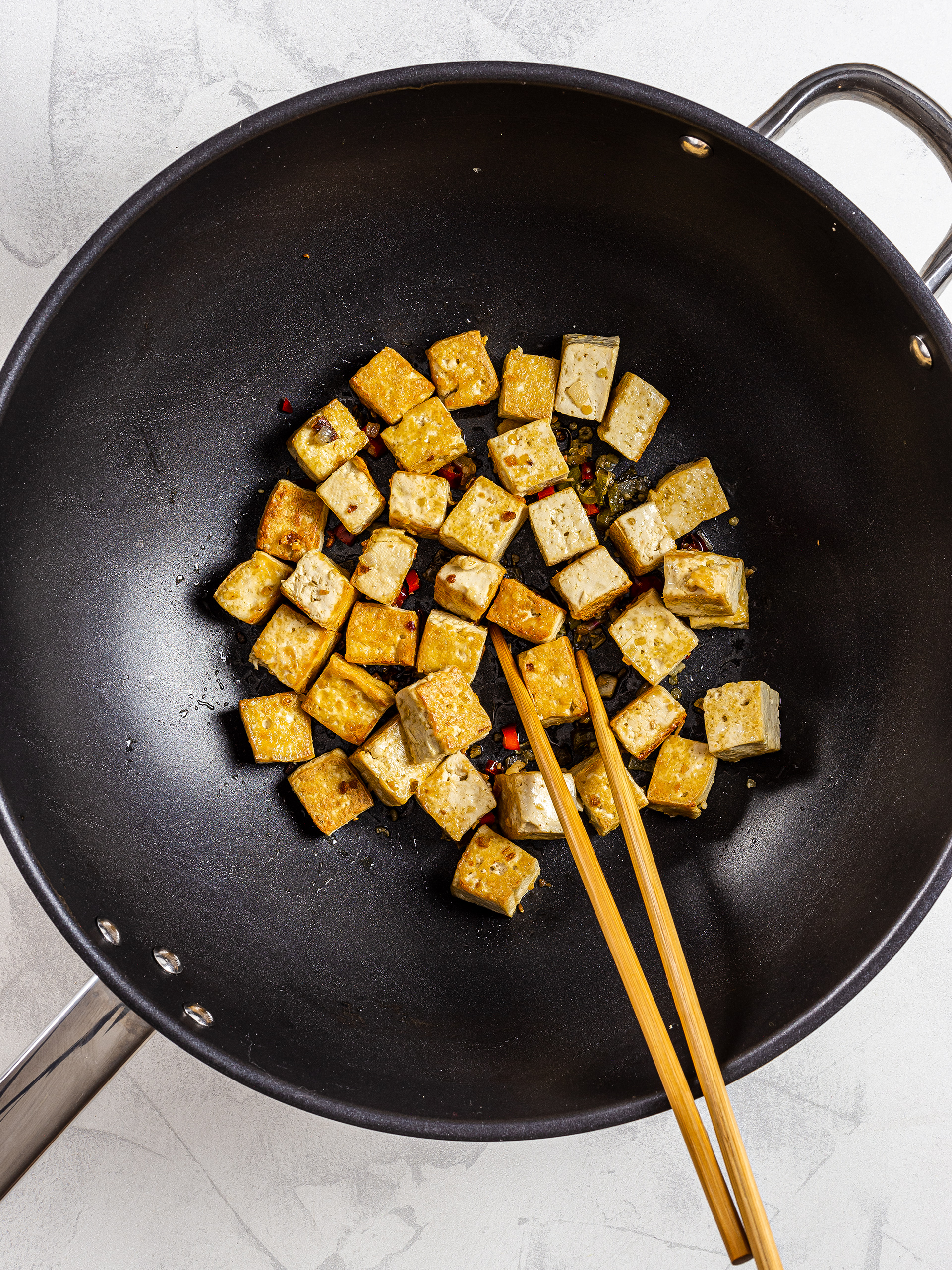 Seared tofu cubes in a wok