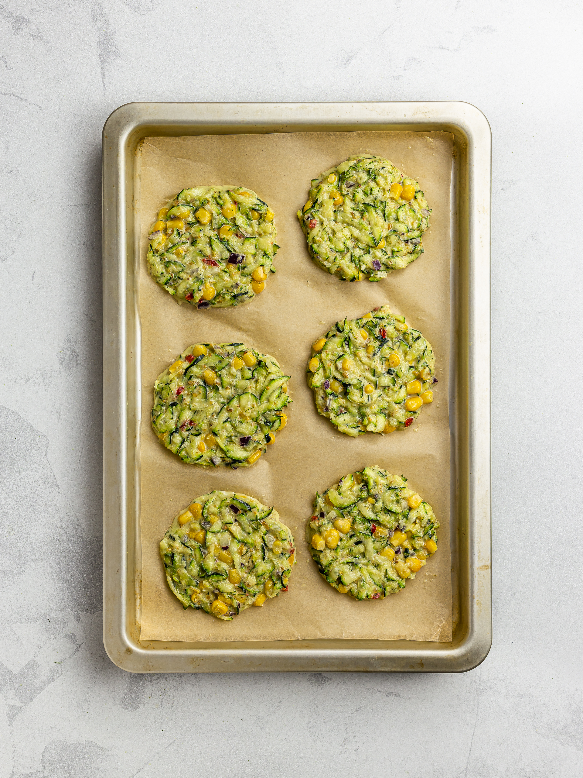 shaped zucchini corn fritters on a tray