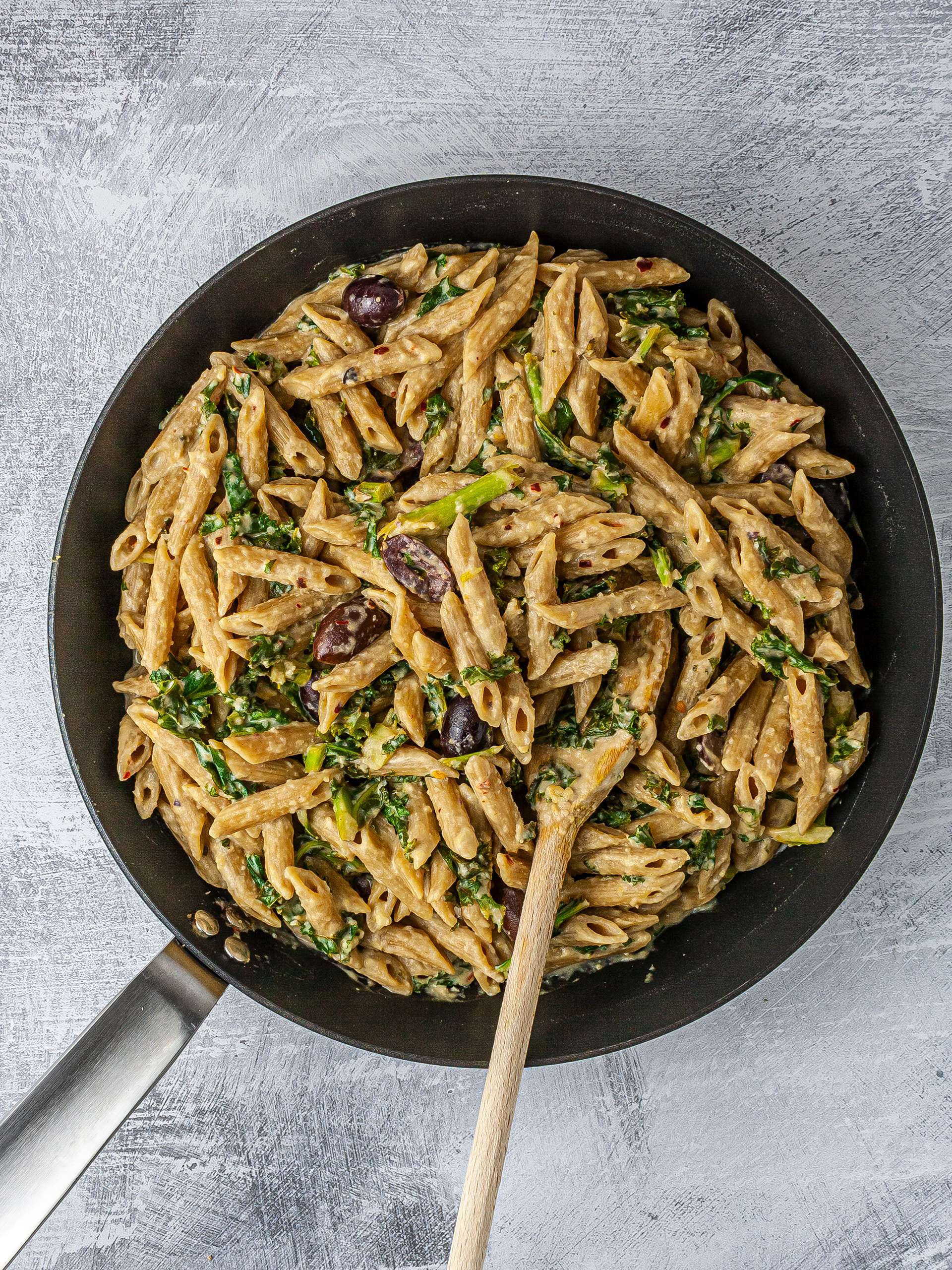 Wholemeal pasta with hummus sauce in a pan.