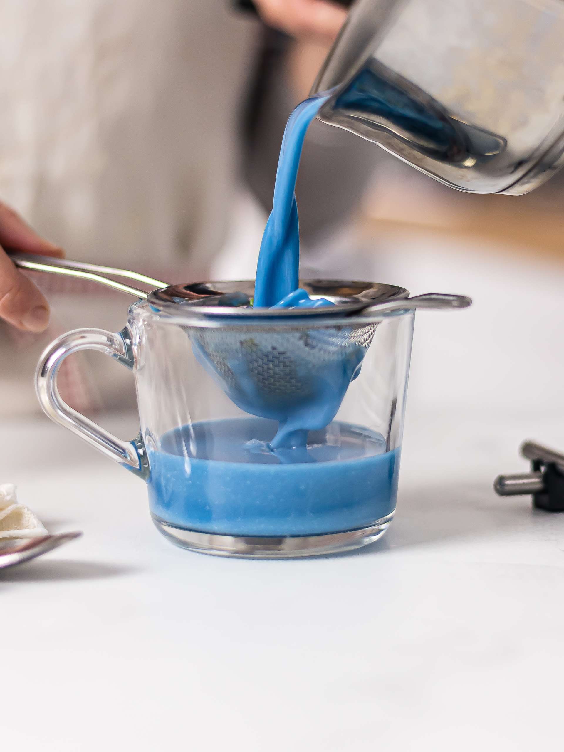 filtering butterfly pea flowers from blue latte