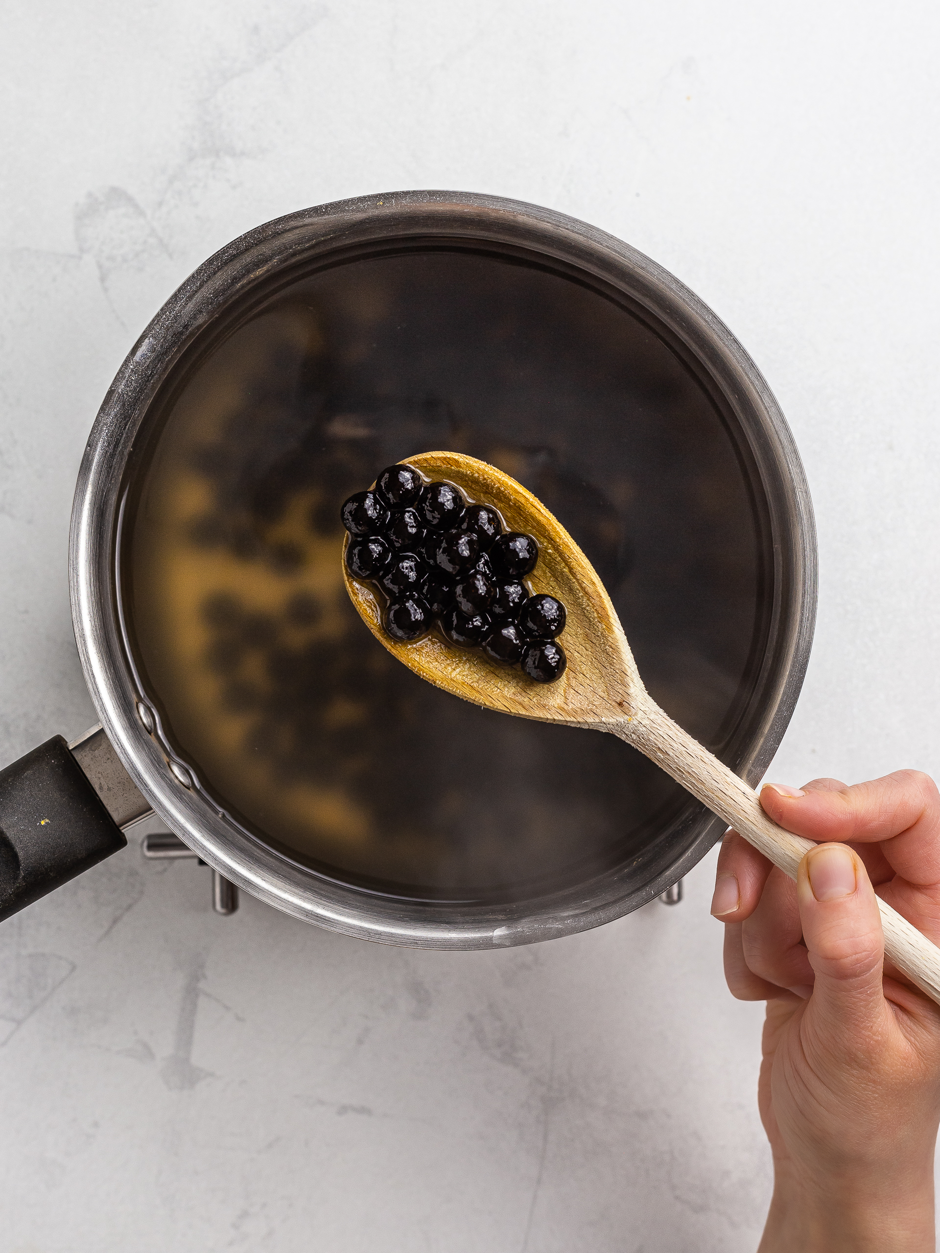 woman cooking tapioca pearls in a pot