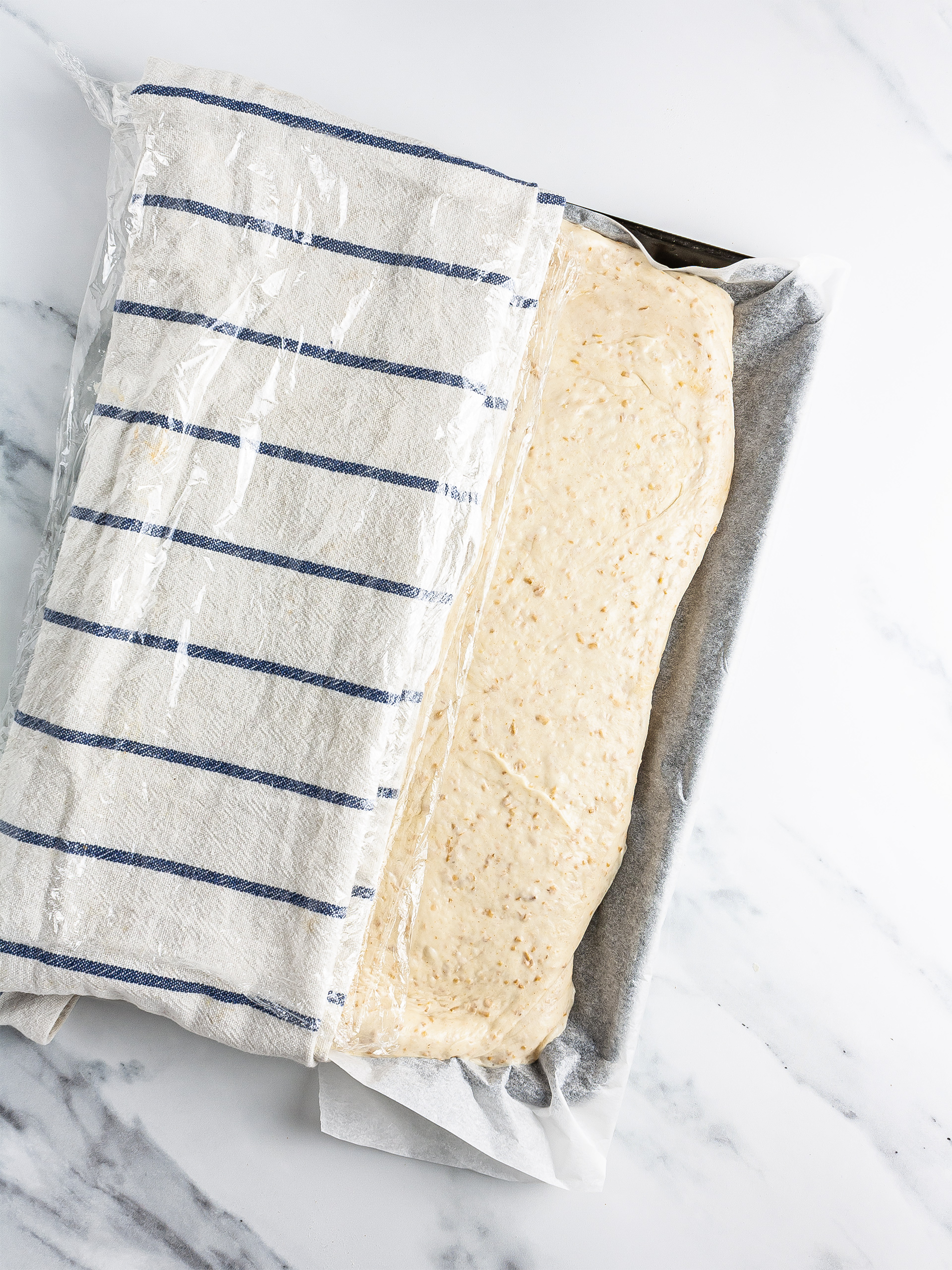 Proved dough on tray covered with a towel