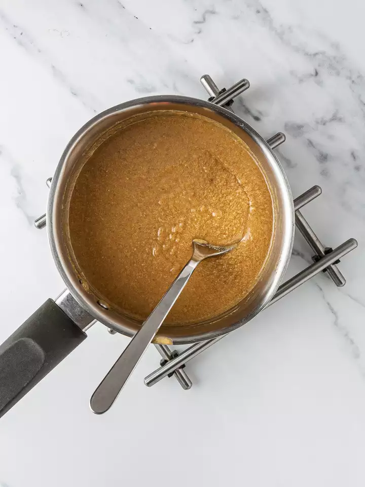 Maple syrup and almond butter melted in a pot.
