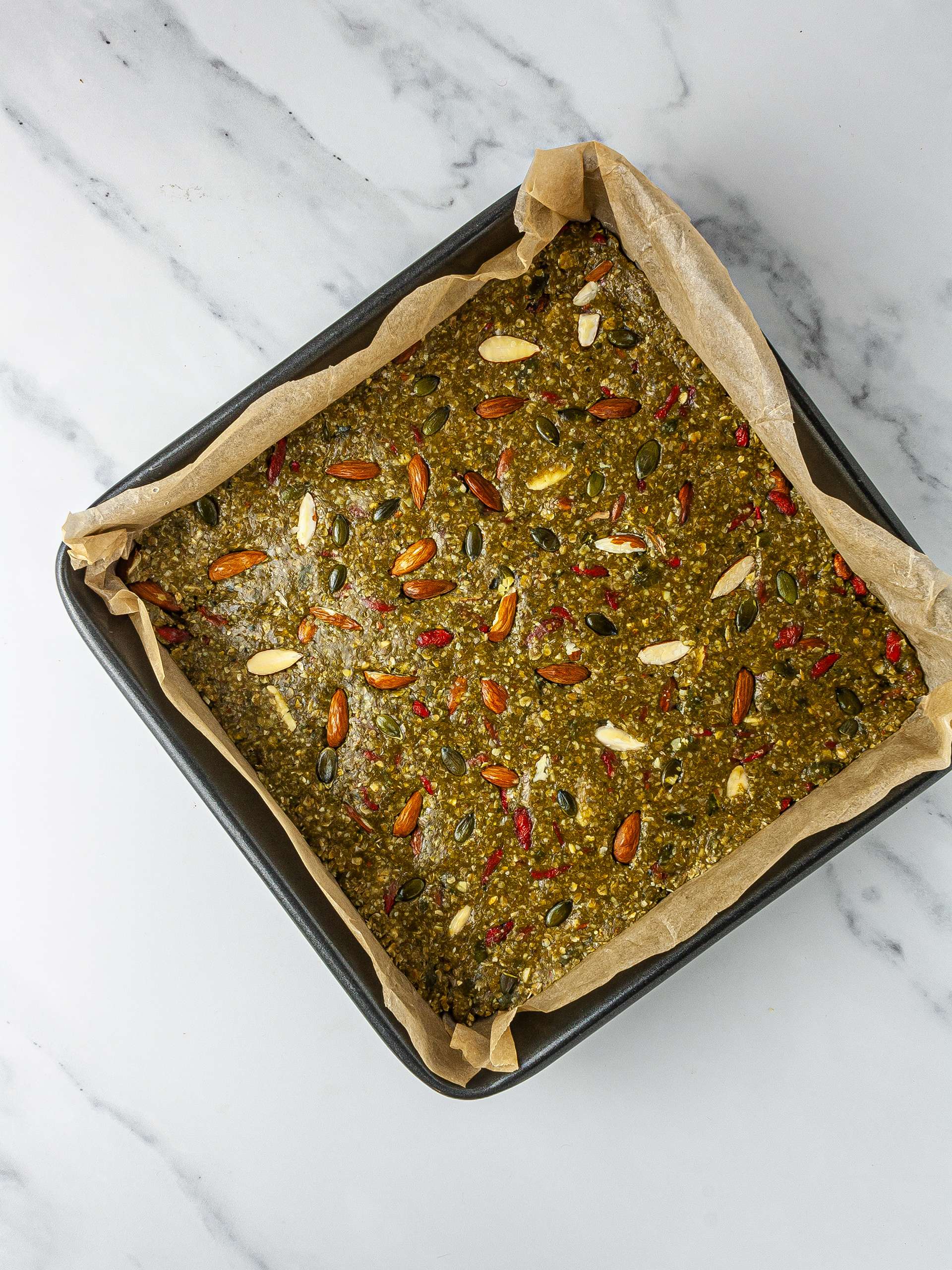 Granola dough packed into a baking tray