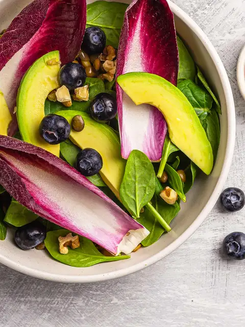 salad with spinach avocado berries and chicory